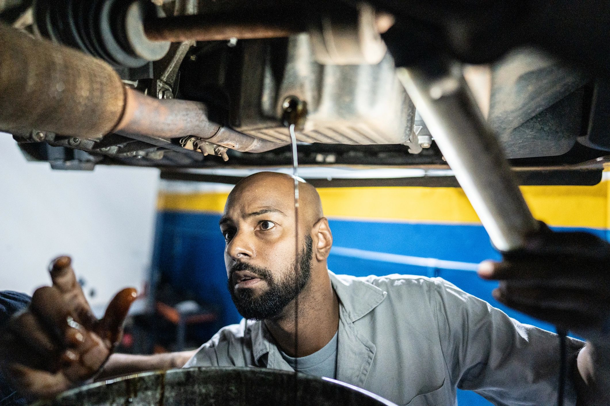 Mechanic performing an oil change in an auto repair shop