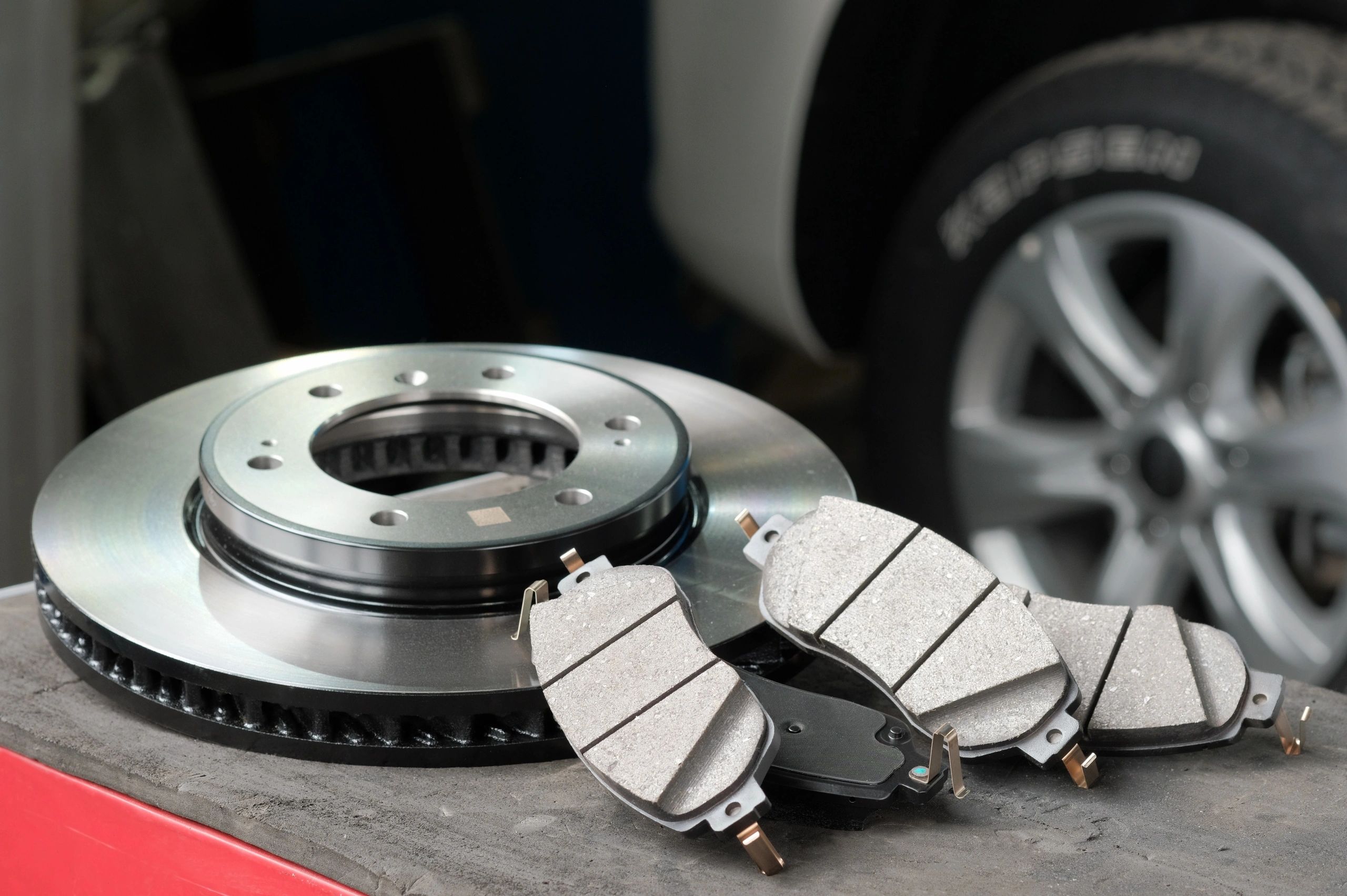 Brake rotor and brake pads on a mechanic’s workbench